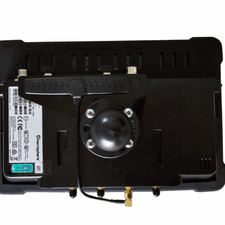 Rear view of a black electronic control module with a white label, mounting screws, and brass fittings along the bottom edge.